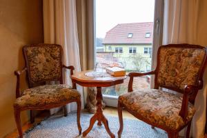 um quarto com duas cadeiras, uma mesa e uma janela em Ferienwohnungen Muehlenblick em Röbel