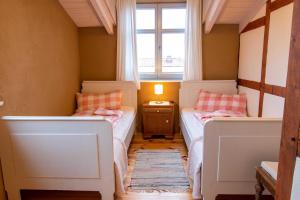 two beds in a small room with a window at Ferienwohnungen Muehlenblick in Röbel