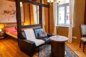 a living room with a chair and a bed at Ferienwohnungen Muehlenblick in Röbel