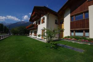 a building with a green lawn in front of it at Casa Caste in Bormio
