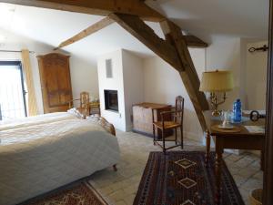 a bedroom with a bed and a table and a desk at Gentilhommière de Collonges in Prissé