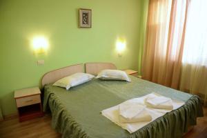 un dormitorio con una cama con dos almohadas encima en Hotel Principal, en Costinesti