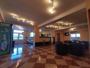 una habitación grande con un bar con sillas y un letrero de bebidas en Hotel Principal, en Costinesti