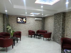 a waiting room with chairs and a tv on a wall at Anya Suit Otel in Denizli