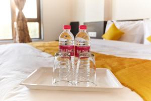 two bottles of water sitting on a tray on a bed at Hotel Sai Bansi in Shirdi