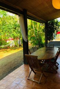 Une table et des chaises en bois sont disponibles sur la terrasse. dans l'établissement MARINA , 2mn à PIEDS PLAGE BOUCAN CANOT, à Saint-Gilles les Bains