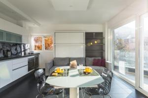 cocina con mesa blanca y sillas en Roggia Apartments by Quokka 360 - central flats with parking space, en Lugano