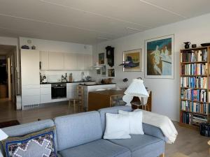 sala de estar con sofá azul y cocina en ApartmentInCopenhagen Apartment 1417, en Copenhague
