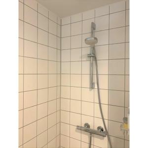 a shower with a shower head in a bathroom at ApartmentInCopenhagen Apartment 1417 in Copenhagen