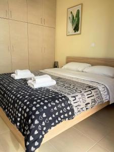 a bedroom with two beds with towels on them at Boho Apartment near Athens Airport in Spáta