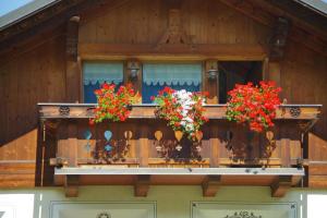 einen Balkon eines Hauses mit Blumen darauf in der Unterkunft Casa Caste in Bormio