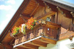 un balcone di una casa con fiori di Casa Caste a Bormio