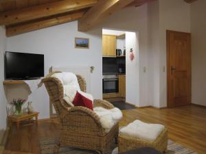 uma sala de estar com duas cadeiras e uma televisão em Hausernhof em Inzell