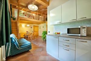 a kitchen with white cabinets and a microwave at Appartamenti Duc De Rohan in Livigno