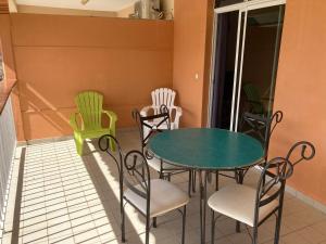 a table and chairs sitting on a balcony at Résidence cabré in Bouillante