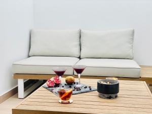 a coffee table with two glasses of wine and a couch at Canaryislandshost l The Secret Suites in Playa Honda