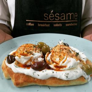 ein weißer Teller mit einem Sandwich mit Früchten und Schlagsahne in der Unterkunft BlackBrick Sandton One in Johannesburg