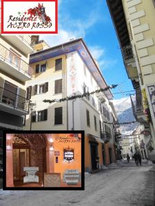 a building with a sign on the side of a street at Residence Acero Rosso in Ponte di Legno