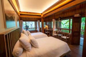 KintamaniにあるTira Vilagna Suites & Spaのベッドルーム1室(ベッド2台、テーブル、椅子付)
