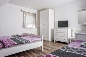 a bedroom with two beds and a tv and a dresser at Chalupa BožíKout - Kouty nad Desnou in Loučná nad Desnou