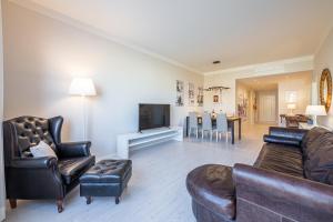 a living room with a couch and chairs and a tv at Frame Apartment in Florence