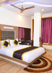 a bedroom with a large bed with a ceiling at Hotel Comfort and Terrace Lounge in Deoghar