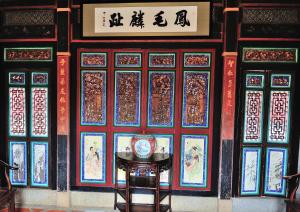 金城凤毛麟趾：金门古厝民宿的一间墙上挂有桌子和绘画的房间