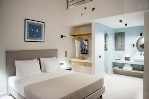 a bedroom with a bed and a bathroom with a sink at Terra Nera Suites in Perivolos