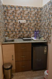 a small kitchen with a sink and a trash can at Hotel Comfort and Terrace Lounge in Deoghar