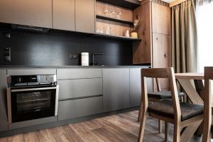 a kitchen with stainless steel appliances and a table and chairs at ZI.INS Apartments in Maranza