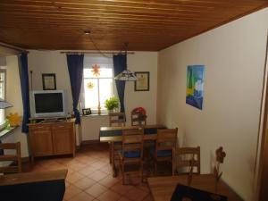 a living room with a table and a television at Weingut-Gästehaus Karl Otto Nalbach in Briedel