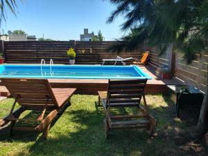 胡安馬達里亞加將軍鎮的住宿－CASA QUINTA，游泳池配有两把椅子、一张桌子和一张桌子,并有四人围栏