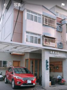 a red car parked in front of a building at Foresweet B&B in Hengchun