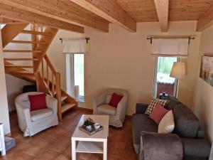 a living room with a couch and chairs and a staircase at Beeck - FeWo mit Terrasse und Strandkorb in Oeversee