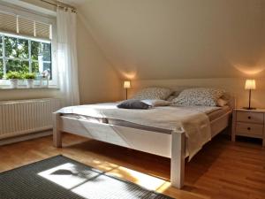a bedroom with a bed and a window at Beeck - FeWo mit Terrasse und Strandkorb in Oeversee