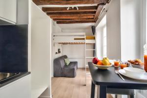 a small kitchen with a table and a loft bed at Cosy Mezzanine Studio in the Heart of Paris (4) in Paris