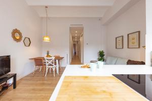 a kitchen and living room with white walls and wooden floors at Bravissimo Riu Onyar in Girona