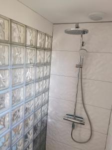 a shower with a shower head in a bathroom at Le Petit Renard in Saint-Jouin-Bruneval