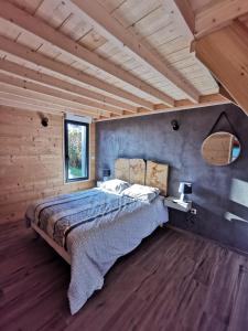 um quarto com uma cama e uma parede de madeira em Le Petit Renard em Saint-Jouin-Bruneval