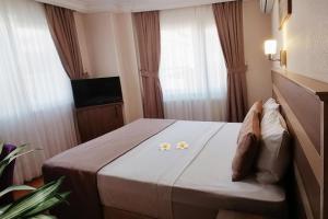 A bed or beds in a room at Sembol Hotel