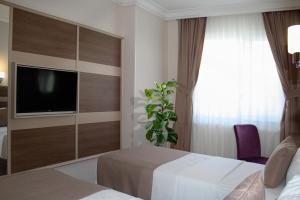 A bed or beds in a room at Sembol Hotel