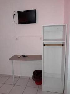 a small bathroom with a refrigerator and a television at Hotel Du Centre in Saint-Denis