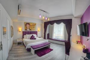 a bedroom with a king sized bed with purple accents at Hotel Andante in Puebla