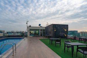 una terrazza panoramica con tavoli, sedie e piscina di Bhagini Icon Premier Hotel a Bangalore