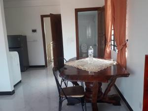 einen Holztisch mit Stühlen und eine Flasche Wasser darauf in der Unterkunft Khun Pich Apartments in Siem Reap