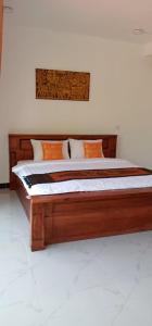 un grande letto in legno in una camera dotata di di Khun Pich Apartments a Siem Reap