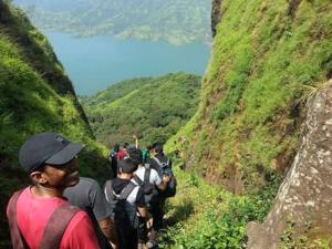 a group of people walking on a mountain trail at I-Camp Resort in Mahabaleshwar