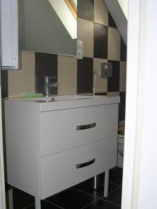 a bathroom with a white sink and a mirror at Gîte de Lavau in Lavau