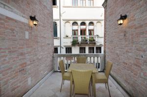 eine Terrasse mit einem Tisch und Stühlen sowie ein Gebäude in der Unterkunft Casa Dei Pittori Venice Apartments in Venedig