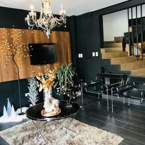 a living room with a table and a chandelier at HOTEL CASA MAYOR LA 70 in Medellín